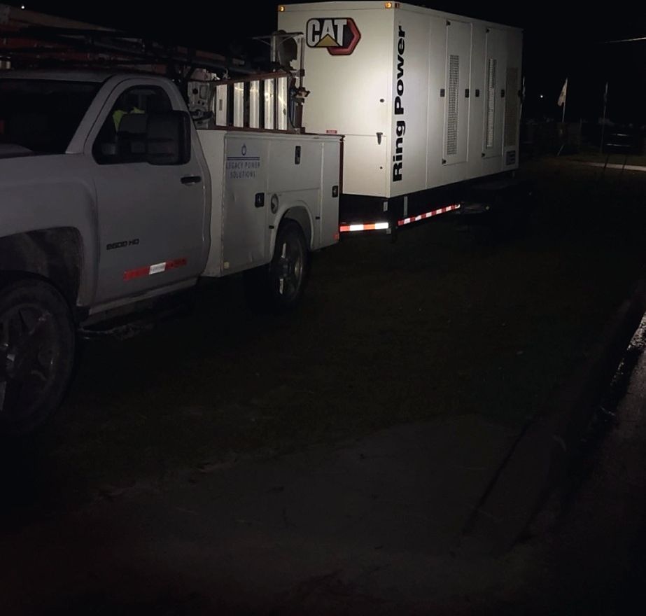 Service truck towing a CAT rental generator to a site after dark
