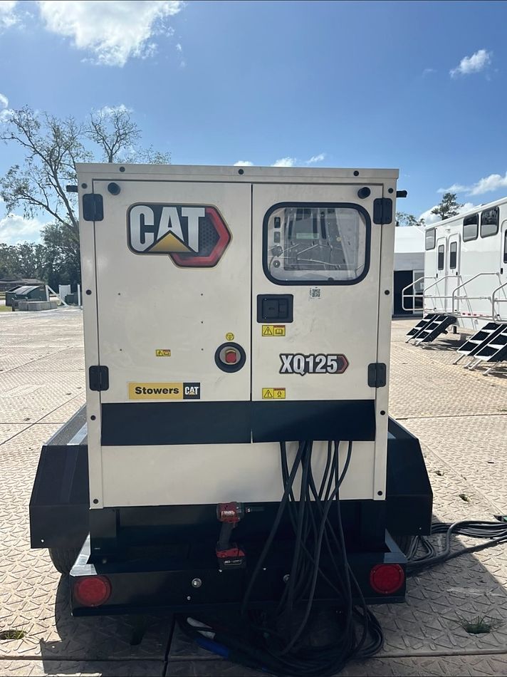 CAT XQ125 mobile generator deployed on site with feeder cables run out