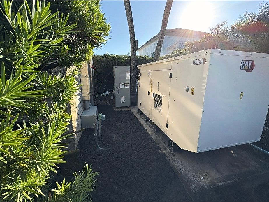 CAT DG80 standby generator installed on a pad beside a commercial building