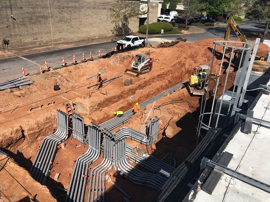 Underground duct bank of PVC conduits swept into a commercial building